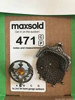 Close-up photo of brooch and purse separately on white background with auction label visible