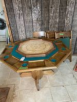 Full view of octagonal game table with six matching chairs, showing wood grain, blue felt, and compartments.