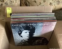 Top down view of the box of vinyl records showing George Thorogood album cover