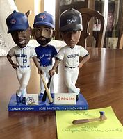 Front view of the 3 Blue Jays bobbleheads Carlos Delgado, Jose Bautista, Vernon Wells, with Jose Bautista's broken right arm placed in front.
