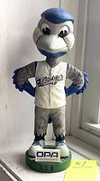 Front view of Bluejay Ace mascot bobblehead wearing jersey with 'Bluejay' text and standing on green base labeled 'OPA Ontario Power Authority' and 'ACE'.