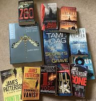 Photo showing a selection of fiction and reference books including multiple titles by James Patterson, Jeffrey Archer, and Tami Hoag, and a Miller's Antiques Price Guide.
