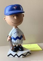 Front view of Charlie Brown bobblehead in Blue Jays uniform holding bat on diamond base