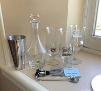 Full view of all items including decanter, glasses, shaker, and bar tools arranged on a windowsill.