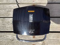 Top view of closed George Foreman grill showing branding and chrome handle.