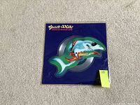 Front side of the shark-shaped vinyl record inside the clear plastic sleeve showing the artwork and title 'Great White House Of Broken Love'.