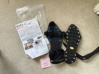 Photo of the pair of Icer's XT anti-skid detachable safety soles size M with instruction sheet and packaging on carpet.