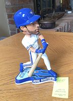 Front and right side view of Jose Bautista bobblehead in batting pose with base showing name and team logo.