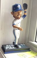 Side view of Kevin Pillar bobblehead in Toronto Blue Jays white uniform and blue cap, glove raised, showing detailed facial features and name on base.