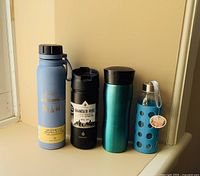 Full view of four bottles showing variety in color and material