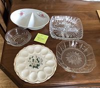 Overview of all five serving plates and dishes together showing variety in material and design