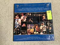 Front cover of The Princes Trust Concert vinyl record set with artist photo collage and shrink wrap.