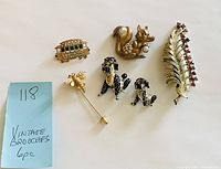 All six brooches arranged on white background with handwritten note showing lot number and quantity.