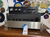 Three stacked amplifiers/preamplifiers on wooden surface