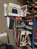Books on floor including title stacks and shelves, visible titles 'Bags to Love', '100 Shoes', 'PUNK 365'
