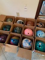 All twelve bowling balls in individual cardboard slots, showing colors and patterns