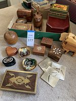 Full view of collection showing various wooden boxes, figurines including a cat, elephant, and apple, and two hand-painted glass dishes.