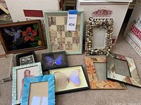 Full view of the collection of framed art and empty frames laid on carpet