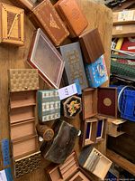 Overview of the collection of wooden and metal jewelry and decorative boxes arranged on a table showing various styles and sizes.