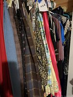 Photo showing various skirts and dresses on hangers, highlighting fabric types and patterns including plaid skirts and printed dresses