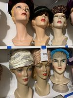 Top and middle shelves showing six heads with hats