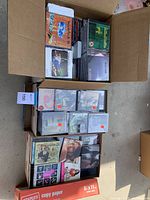Three boxes filled with music CDs by various artists. Covers include Woodstock 94, Dexter, Blind Tribe, and Rockestar Recordings Summer Sampler 2003.