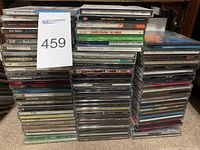 Three stacks of CD jewel cases with various artists visible such as Hoobastank, Weezer, Paul Weller, The Vines, B.L.X., and more.