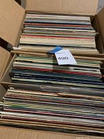 Two open cardboard boxes filled with vinyl record sleeves