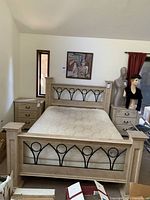 Full view of queen bed frame with mattress and two nightstands in a bedroom.