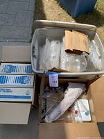 Box with assorted vintage Pyrex scientific glassware, including several beakers, flasks, some bubble wrapped and a paper bag