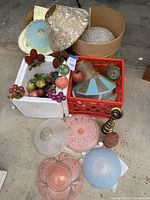 Overview of the lot showing various lampshades, beaded fruit decoration, and lamp bases including pink ceramic and brass candlestick.