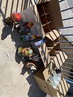 Overview of statues arranged outside next to cardboard boxes, showing all items and condition