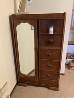 Front view of wooden wardrobe showing mirror door on left, five drawers on right, wood finish and metal handles