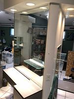 Photo of the back side of the styling station showing the large mirror and lighting above the station.