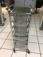 Front view of the metal cart showing seven mesh wire drawers and roller blade wheels.