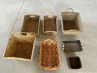 Top view of all eight rectangular baskets arranged on concrete floor showing size and color differences