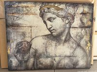 Canvas print showing a Roman-style head holding an apple with gold and grey tones