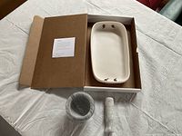 Casserole dish inside cardboard box with mortar and pestle set on table