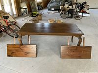Front view of pine dining table with two detached leaves placed on the floor in front.