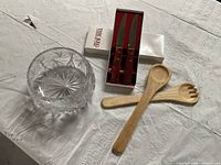 Overview of salad bowl, salad spoons, and boxed vintage steak knives on tablecloth
