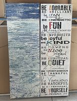 Two vertical prints leaning against a wall, one showing an ocean scene and the other with a collection of inspirational phrases.