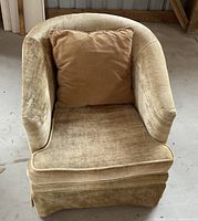 Front view of the champagne velvet tub chair with cushioned seat and matching pillow.