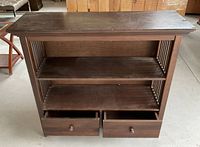 Front view of wood sideboard showing two drawers open and two shelves.