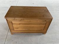 Front view of the rectangular wooden chest showing simple panel detailing.