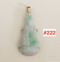 Full frontal view of carved jade Buddha pendant with gold prong setting
