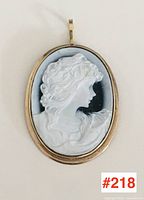 Front view of oval cameo pendant showing carved female profile and gold frame