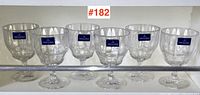 Six clear Villeroy & Boch glass goblets arranged in a row on a shelf