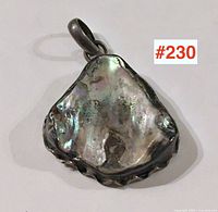 Front view of the abalone pendant showing the shell's iridescent surface and sterling silver mount with scalloped edge.