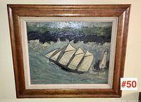 Front view of frame containing folk art painting of four-masted schooner and lighthouse