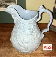 Front view showing full relief decoration of cherub and grape clusters